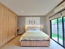 Modern bedroom with built-in wardrobe and large sliding glass door