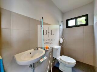 Modern bathroom with sink, toilet, and shower.