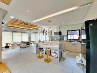 Modern kitchen and dining area with bar stools and natural lighting