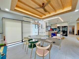 Modern kitchen with dining table and chairs, wooden ceiling, and open layout