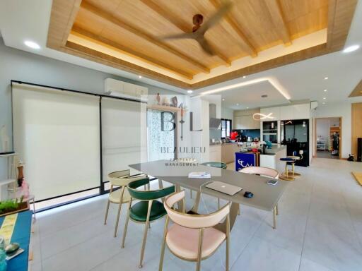 Modern kitchen with dining table and chairs, wooden ceiling, and open layout