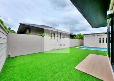 Backyard with green artificial grass and swimming pool