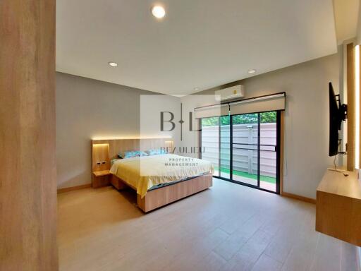 Spacious modern bedroom with large bed and sliding glass doors