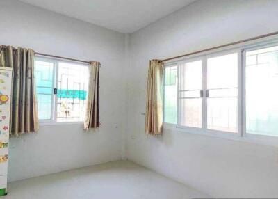 Bright bedroom with large windows and a green wardrobe