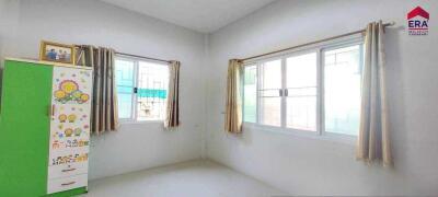 Bright bedroom with large windows and a green wardrobe