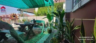 Outdoor patio with seating and plants under a shaded canopy