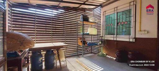 Covered outdoor patio with wooden slat walls and storage shelves