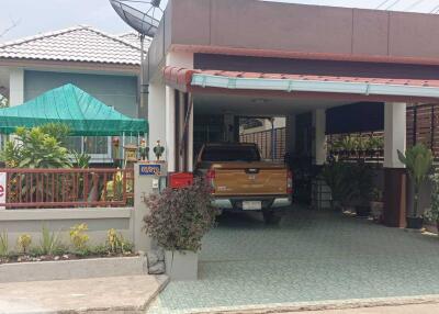 Front view of a residential property with a carport and garden