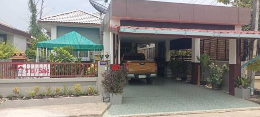 Front view of a residential property with a carport and garden