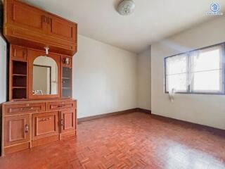 Empty bedroom with wooden cabinet and window