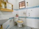 Bathroom with tiled floor and walls, single window, shower, sink, and toilet