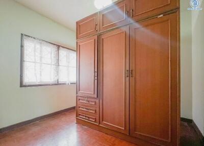 Bedroom with large wooden wardrobe and window