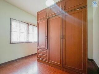 Bedroom with large wooden wardrobe and window