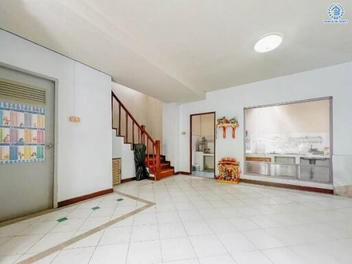 Spacious living area with stairs to the upper floor and a view into the kitchen