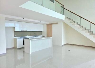 Modern kitchen with a central island and staircase view