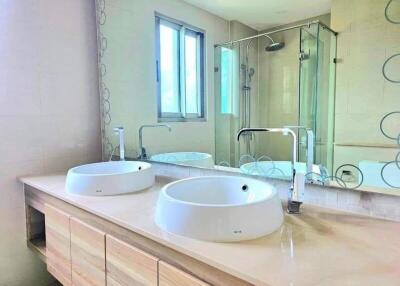 Modern bathroom with double sinks and glass shower enclosure