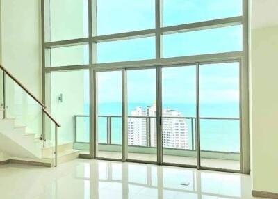 spacious living room with tall windows and ocean view