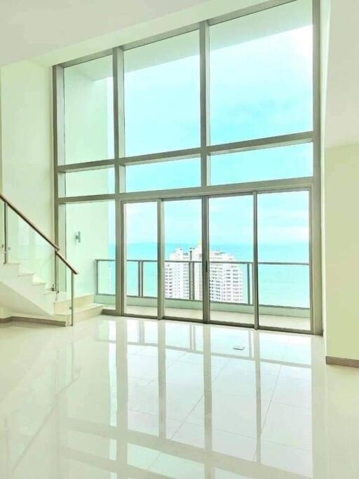 spacious living room with tall windows and ocean view