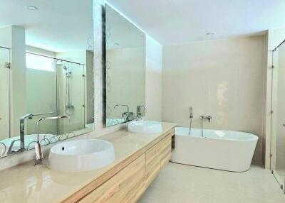 Modern bathroom with double sinks, bathtub, and shower