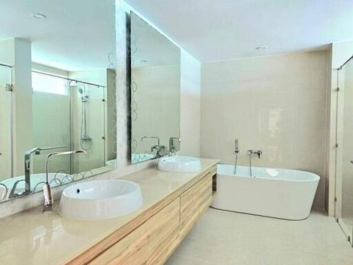 Modern bathroom with double sinks, bathtub, and shower