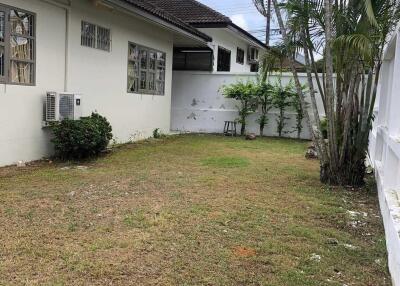 Backyard area with green lawn and exterior view of the house