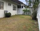 Backyard area with green lawn and exterior view of the house