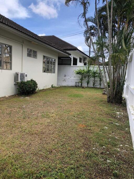 Backyard area with green lawn and exterior view of the house