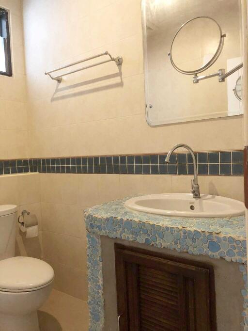 Bathroom with a toilet, sink, and mirror