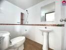 Modern bathroom with white fixtures and a walk-in shower.