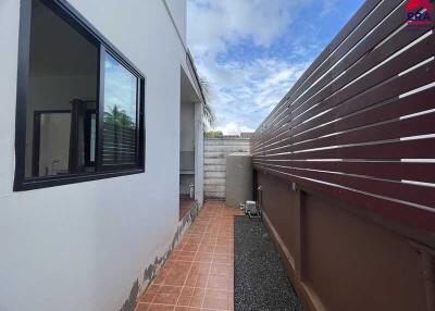 Outdoor corridor with tiled flooring and wooden fence