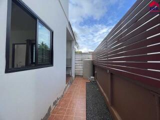 Outdoor corridor with tiled flooring and wooden fence