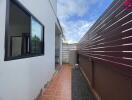 Outdoor corridor with tiled flooring and wooden fence