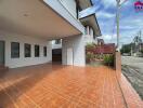 Outdoor view of building with covered walkway and tiled ground