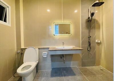 Modern bathroom with a toilet, sink, and shower