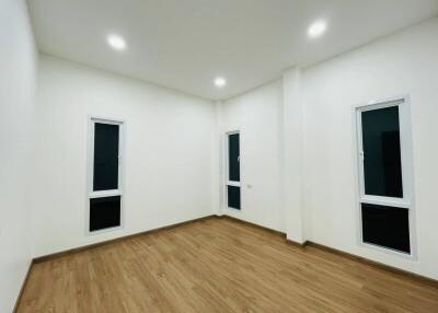 Empty bedroom with hardwood flooring and recessed lighting