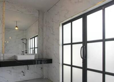 Modern bathroom with large window and marble finishes