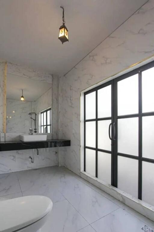 Modern bathroom with large window and marble finishes