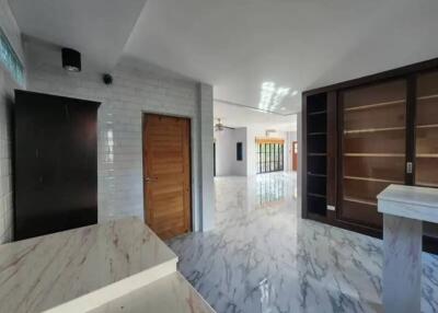 Spacious and modern living area with marble flooring and ample built-in storage