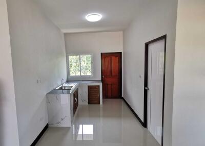 Small kitchen area with a window and wooden door