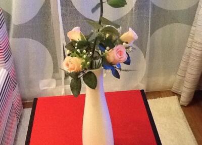 Flower vase on table with decorative curtain background