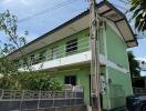 Two-story green residential building exterior