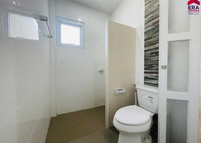 Modern bathroom with tile accents and wall-mounted toilet