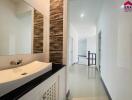 Modern bathroom with a sink and hallway view