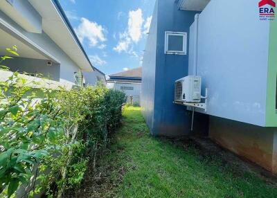 Side view of house with garden and air conditioning unit