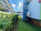 Side view of house with garden and air conditioning unit