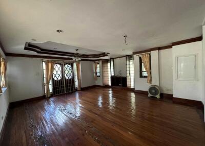 Spacious and empty living room with wooden flooring and ceiling fan