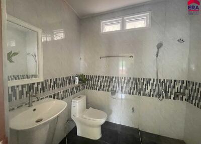 Modern bathroom with white fixtures and tiled walls