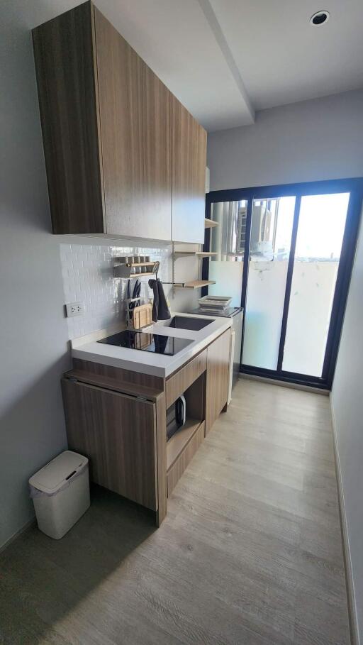 Modern kitchen with wooden cabinetry and large window