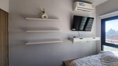 Bedroom with wall-mounted TV and air conditioning