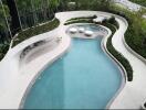 luxurious outdoor pool area with seating and greenery